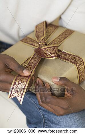 African man holding gift View Large Photo Image Stock Photograph - African man holding gift. Fotosearch