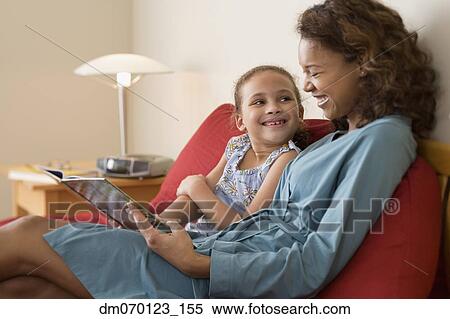 African mother reading to daughter View Large Photo Image Stock Photography - African mother reading to daughter. Fotosearch