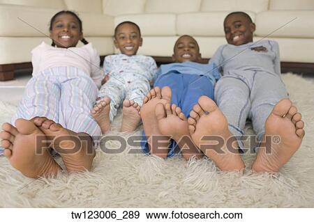 Stock Photo - African siblings in pajamas on floor. Fotosearch