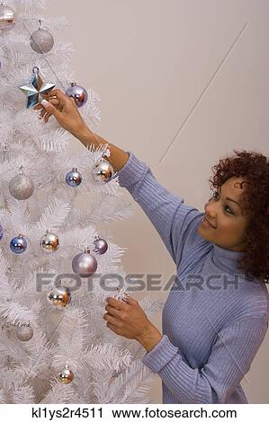 African woman hanging Christmas ornament View Large Photo Image Stock Image - African woman hanging Christmas ornament. Fotosearch