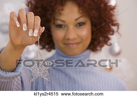 African woman holding Christmas ornament View Large Photo Image Stock Photography - African woman holding Christmas ornament. Fotosearch