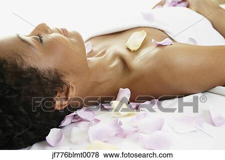 Stock Photo - African woman laying on spa table. Fotosearch