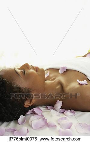 Stock Photography - African woman laying on spa table. Fotosearch
