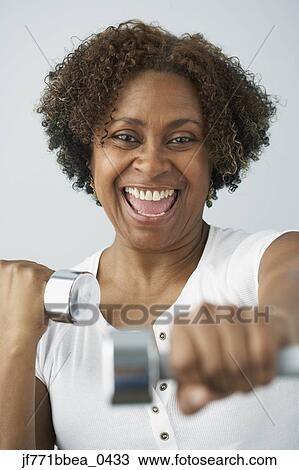 Stock Image - African woman lifting weights. Fotosearch