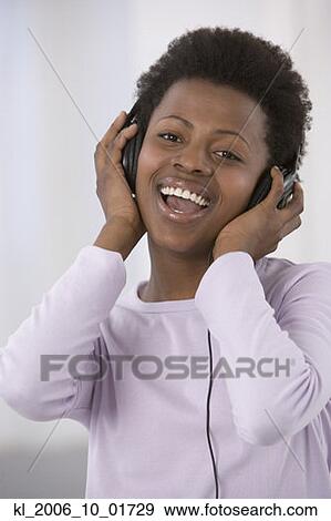 African woman listening to headphones View Large Photo Image Stock Photo - African woman listening to headphones. Fotosearch