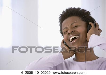 African woman listening to headphones View Large Photo Image Stock Photo - African woman listening to headphones. Fotosearch