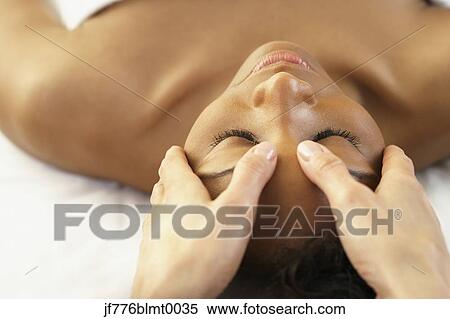 Stock Photography - African woman receiving facial massage. Fotosearch