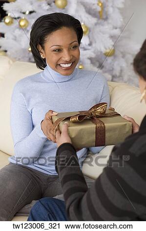 Stock Image - African woman receiving gift from mother. Fotosearch