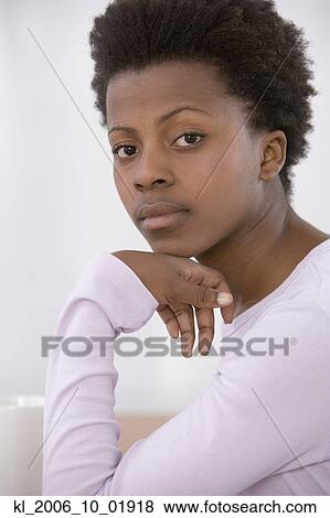 Stock Photo - African woman resting chin on hand. Fotosearch
