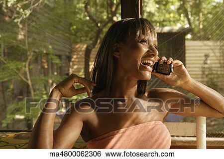 Stock Photograph - African woman talking on cell phone. Fotosearch