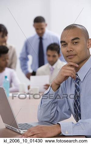 Asian businessman next to laptop View Large Photo Image Stock Image - Asian businessman next to laptop. Fotosearch
