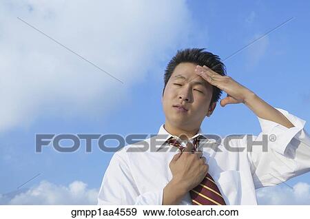 Stock Photo - Asian businessman rubbing forehead. Fotosearch