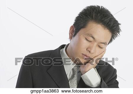 Stock Image - Asian businessman sleeping. Fotosearch