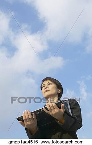Asian businesswoman holding laptop View Large Photo Image Stock Photograph - Asian businesswoman holding laptop. Fotosearch