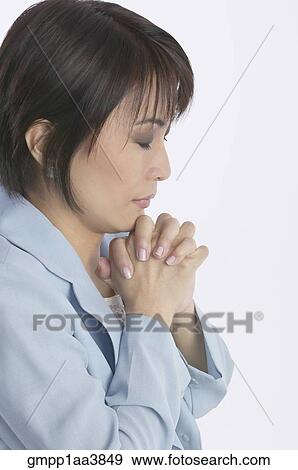 Stock Photo - Asian businesswoman praying. Fotosearch
