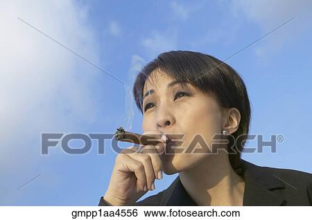 Asian businesswoman smoking cigar View Large Photo Image Stock Photograph - Asian businesswoman smoking cigar. Fotosearch