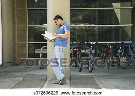 Asian man reading paperwork outdoors View Large Photo Image Stock Photograph - Asian man reading paperwork outdoors. Fotosearch