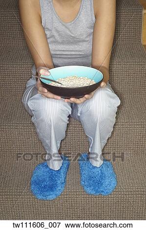 Asian woman eating cereal on stairs View Large Photo Image Stock Photo - Asian woman eating cereal on stairs. Fotosearch