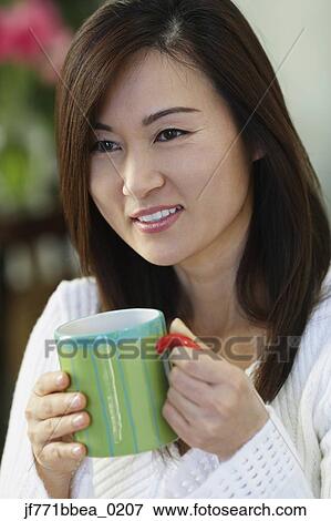Asian woman holding coffee mug View Large Photo Image Stock Photo - Asian woman holding coffee mug. Fotosearch