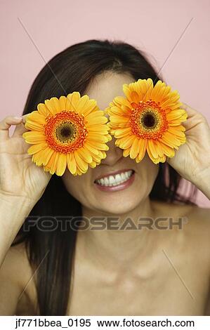 Asian woman holding flowers over eyes View Large Photo Image Stock Photography - Asian woman holding flowers over eyes. Fotosearch