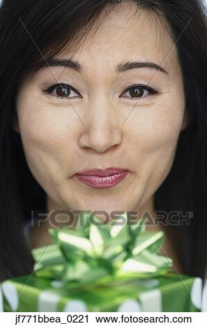 Asian woman holding gift View Large Photo Image Stock Image - Asian woman holding gift. Fotosearch