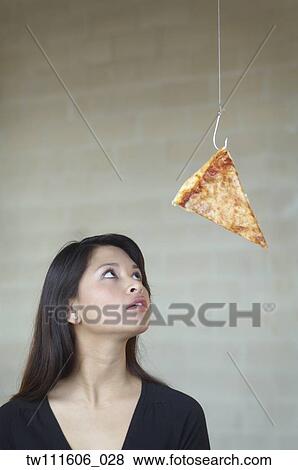 Asian woman looking at pizza on hook View Large Photo Image Stock Photo - Asian woman looking at pizza on hook. Fotosearch