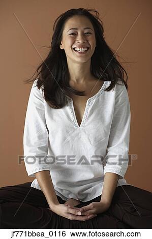 Stock Photograph - Asian woman sitting cross legged. Fotosearch