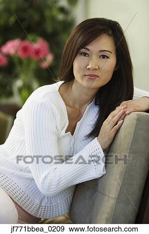Asian woman sitting on chair View Large Photo Image Stock Photo - Asian woman sitting on chair. Fotosearch