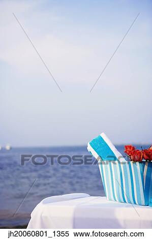 Stock Photography - Beach towel and roses at beach. Fotosearch