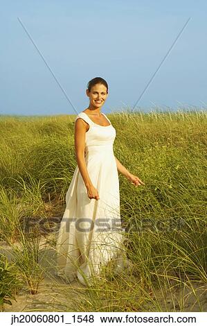 Bride standing in dune grass View Large Photo Image Stock Photo - Bride standing in dune grass. Fotosearch