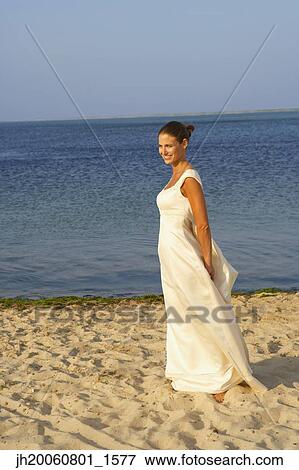 Stock Photo - Bride walking on beach. Fotosearch