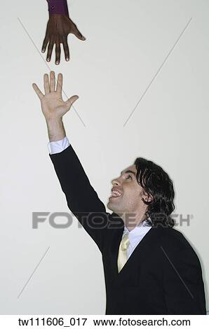 Businessman reaching up for hand View Large Photo Image Stock Photo - Businessman reaching up for hand. Fotosearch
