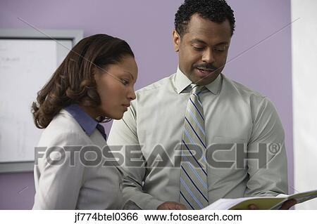 Stock Photograph - Businesspeople looking at paperwork. Fotosearch