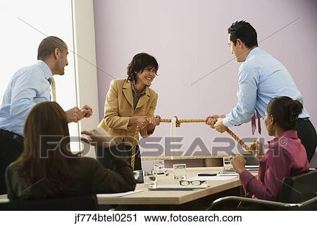 Businesspeople playing tug of war View Large Photo Image Stock Image - Businesspeople playing tug of war. Fotosearch
