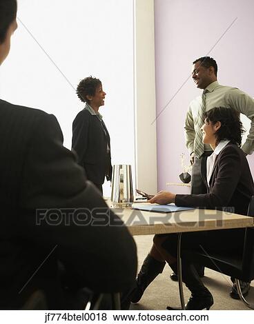 Stock Photo - Businesspeople talking in conference room. Fotosearch