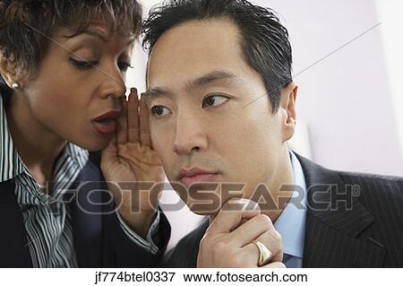 Businesswoman telling secret to businessman View Large Photo Image Stock Photo - Businesswoman telling secret to businessman. Fotosearch