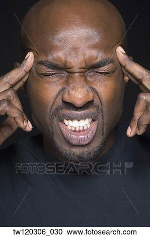 Close up of African man rubbing temples View Large Photo Image Stock Image - Close up of African man rubbing temples. Fotosearch