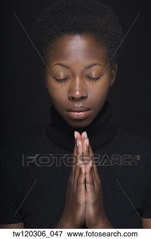Stock Photo - Close up of African woman praying. Fotosearch