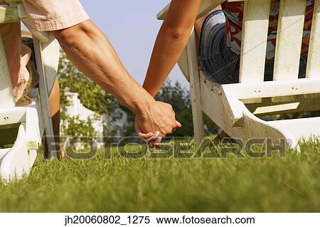 Stock Photography - Close up of couple holding hands. Fotosearch