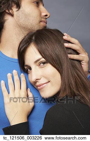 Stock Photograph - Close up of Hispanic couple hugging. Fotosearch