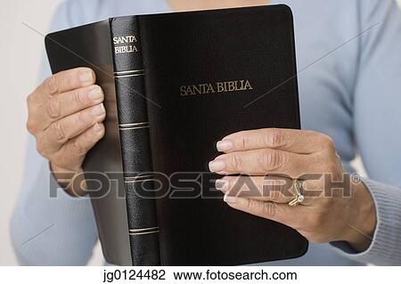 Close up of woman holding Spanish bible View Large Photo Image Stock Image - Close up of woman holding Spanish bible. Fotosearch
