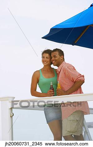 Couple having drinks on balcony View Large Photo Image Stock Photography - Couple having drinks on balcony. Fotosearch