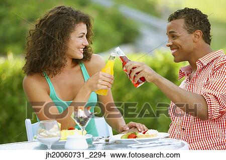 Couple toasting at outdoor restaurant View Large Photo Image Picture - Couple toasting at outdoor restaurant. Fotosearch