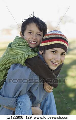 Hispanic boy giving brother piggyback ride View Large Photo Image Stock Photo - Hispanic boy giving brother piggyback ride. Fotosearch