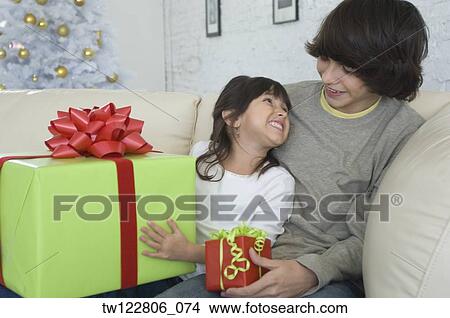 Hispanic brother and sister exchanging Christmas gifts View Large Photo Image Picture - Hispanic brother and sister exchanging Christmas gifts. Fotosearch