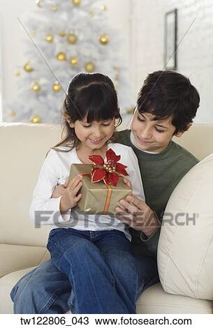 Hispanic brother and sister holding Christmas gift View Large Photo Image Stock Image - Hispanic brother and sister holding Christmas gift. Fotosearch