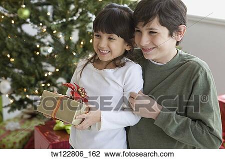 Hispanic brother and sister holding Christmas gift View Large Photo Image Stock Image - Hispanic brother and sister holding Christmas gift. Fotosearch