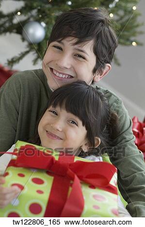 Hispanic brother and sister holding Christmas gift View Large Photo Image Stock Photography - Hispanic brother and sister holding Christmas gift. Fotosearch
