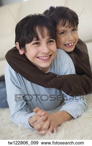 Hispanic brothers hugging on floor View Large Photo Image Stock Photo - Hispanic brothers hugging on floor. Fotosearch