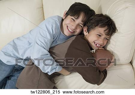 Hispanic brothers hugging with football View Large Photo Image Stock Photography - Hispanic brothers hugging with football. Fotosearch